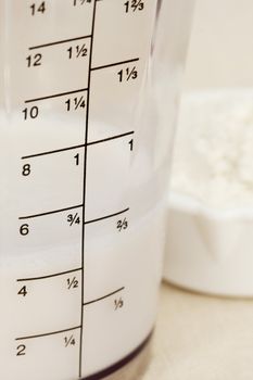 almond milk in blender beaker with ounces and cup scale and a scoop of white powder