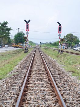 Railroad with crossing sign in countryside of Thailand