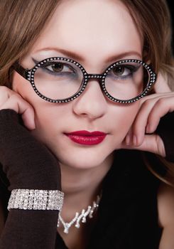 portrait of a young girl with glasses, looking at the camera.