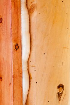 Polyurethane foam seals gap in wooden frame construction conserving energy.