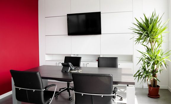 Interior office building with furniture and a red wall