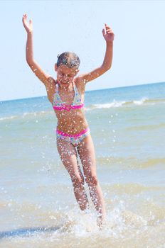 A happy child is running at the beach.