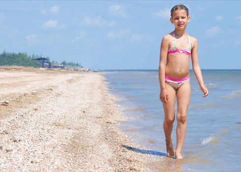 A happy child is running at the beach.