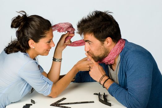 Couple in a playful mood with domino stones on the  table