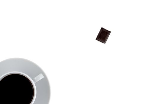 Minimilistic top view of coffee cup with black coffee and a piece of chocolade