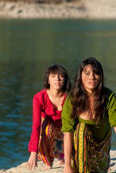 Mother and daugher at early morning yoga exercises