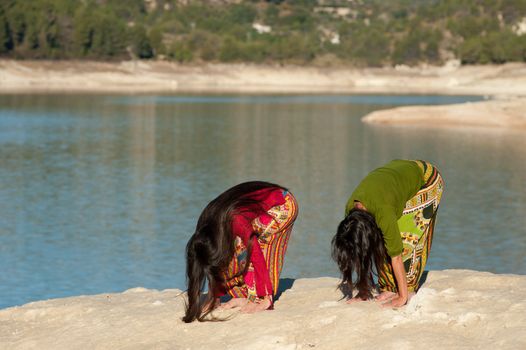 Mother and daugher at early morning yoga exercises