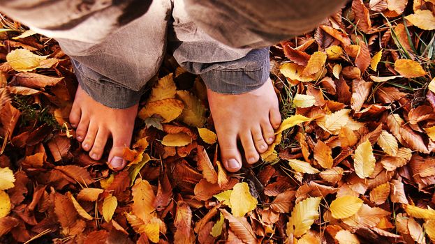 standing with bare foots in the autumn leaves