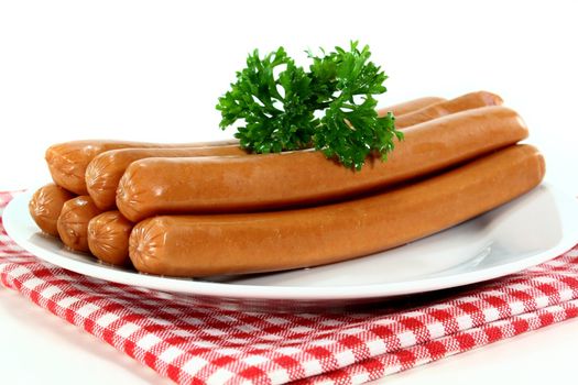 Vienna sausages and parsley on a white plate