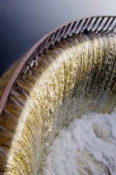 Pond water runs through the dam. Beautiful view of flowing water.