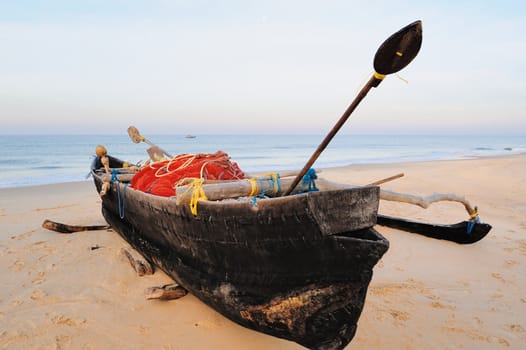 Old fishing boat on the sandy beach in Goa