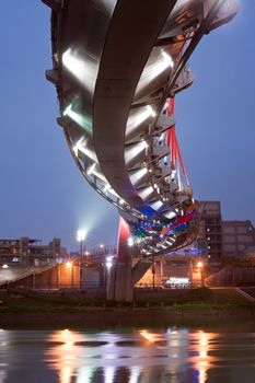 Colorful bridge in red over river in night in modern city in Taipei, Taiwan, Asia.