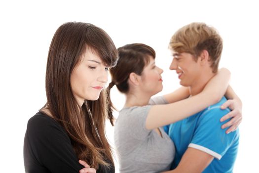 Sad brunette girl jealousy about her friend. Isolated on white background.