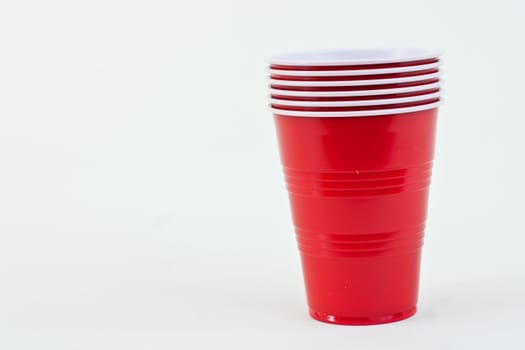 Red plastic cups in a stack on a white background.