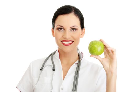 Healthy eating or lifestyle concept. Smiling woman doctor with a green apple.