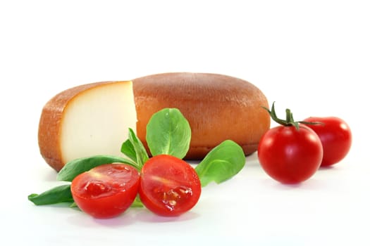 a wheel of cheese with fresh tomatoes and corn salad