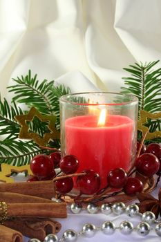 a burning candle with Christmas decorations