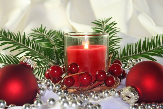 a burning candle with Christmas decorations