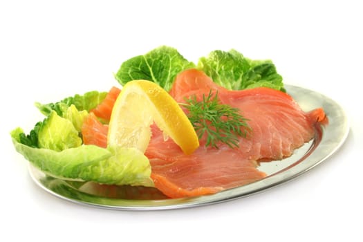 Salmon with lemon slices and dill on green salad