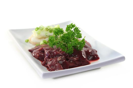 raw liver with onions on a white plate