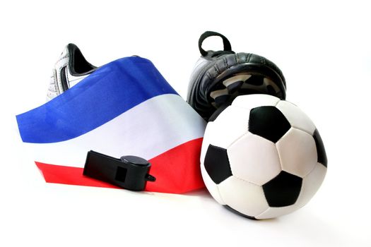 Soccer shoes with flag, leather ball and whistle on a white background