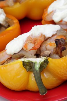 Closeup photo of stuffed pepper with shrimps, mushrooms, onion and sour cream