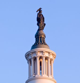 Brightly lit dawn sky behind the Statue of Freedom on the dome of the Capitol in Washington DC