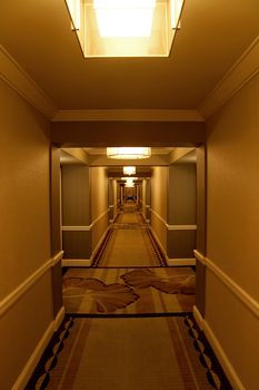 A long modern hotel hallway with rooms on either side