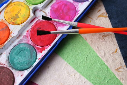 Paint Brushes, Paint and different colored handmade paper