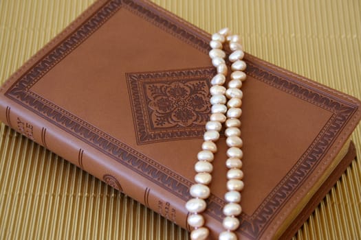 Pearls on a leather bound cover with patterns