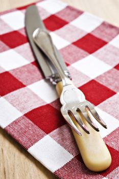 Antique knife and fork on a red and white cloth