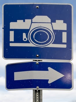 Point-of-interest blue road sign with white camera icon and directional arrow.