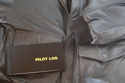A Pilots log sits on top of a leather A4 aviator jacket