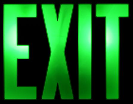 A green illuminated Exit sign isolated on a black background.