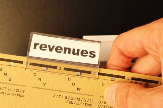 revenue or revenues word on business office folder showing financial success