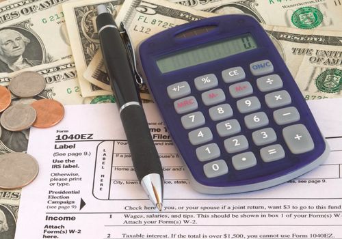 Tax Form with calculator, pen and money