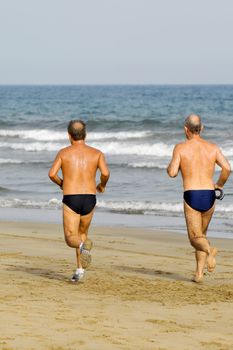 Old men is running on the beach