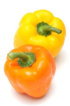 Two peppers, orange and yellow, isolated on white background