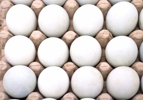 Dozen white fresh eggs in a cardboard