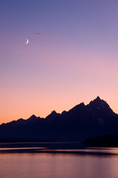 Jackson Lake, the Teton Mountains and a crescent Moon at sunset, Grand Teton National Park, Wyoming, USA
