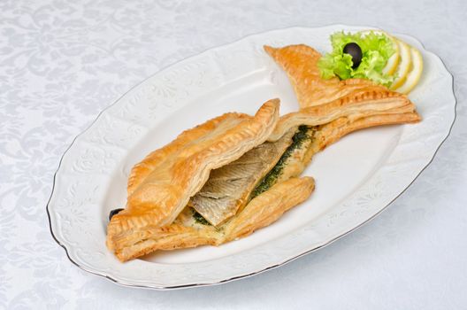 tasty dish of trout fish baked with greens at dough