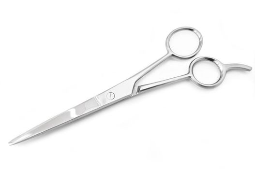 Close up of a single pair of stainless steel hairdressing scissors arranged over white
