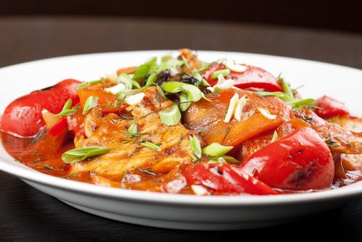 pork meat with tomato, pepper, prunes, garlic and green onion