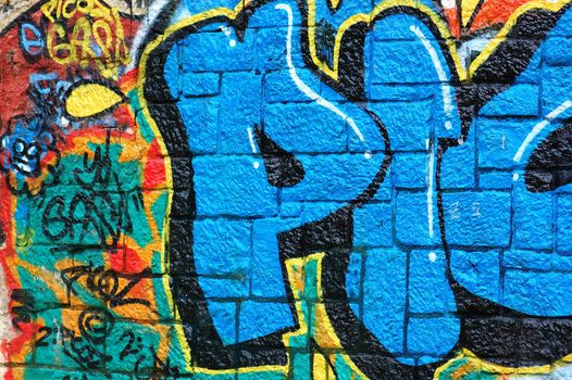 Rough wall surface covered with colorful graffiti. Urban street art background.