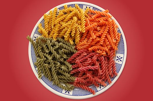 Plate with four flavors of italian fusilli pasta. Food background.