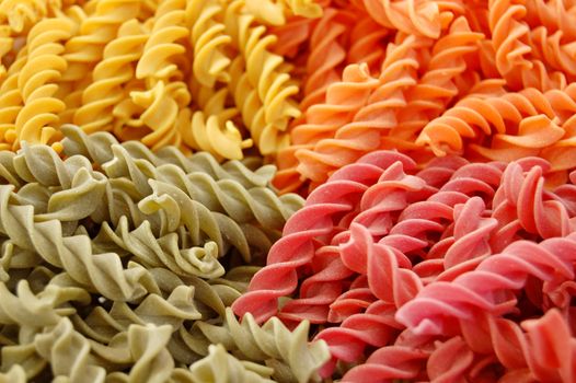 Four flavors of fusilli pasta. Italian food background.