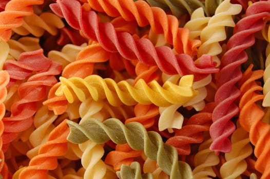 Many different flavors of twirls pasta. Italian food background detail.
