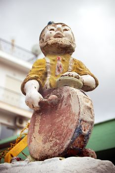 Vintage weathered decorative garden gnome with drum.