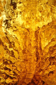 Yellow stained glass reflections golden texture. Abstract background pattern.