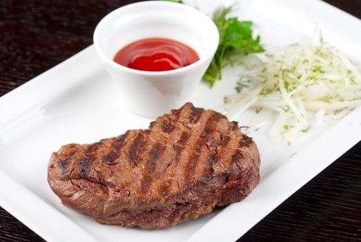 Juicy roasted beef steak with vegetables closeup at plate